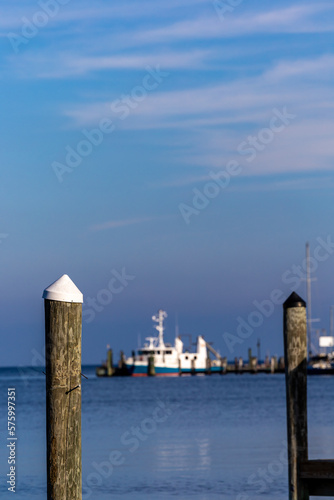 Solomons, Maryland ,USA White- topped pylons in a marina on the Patuxent River and a boat. © Alexander