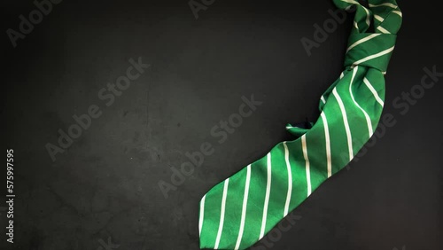 Elegant green business tie on dark background Elegant man clothes concept. wardobe and accessories for official party or evening meeting. Placed on black backgound. tie. Top view. Flat lay with copy m photo