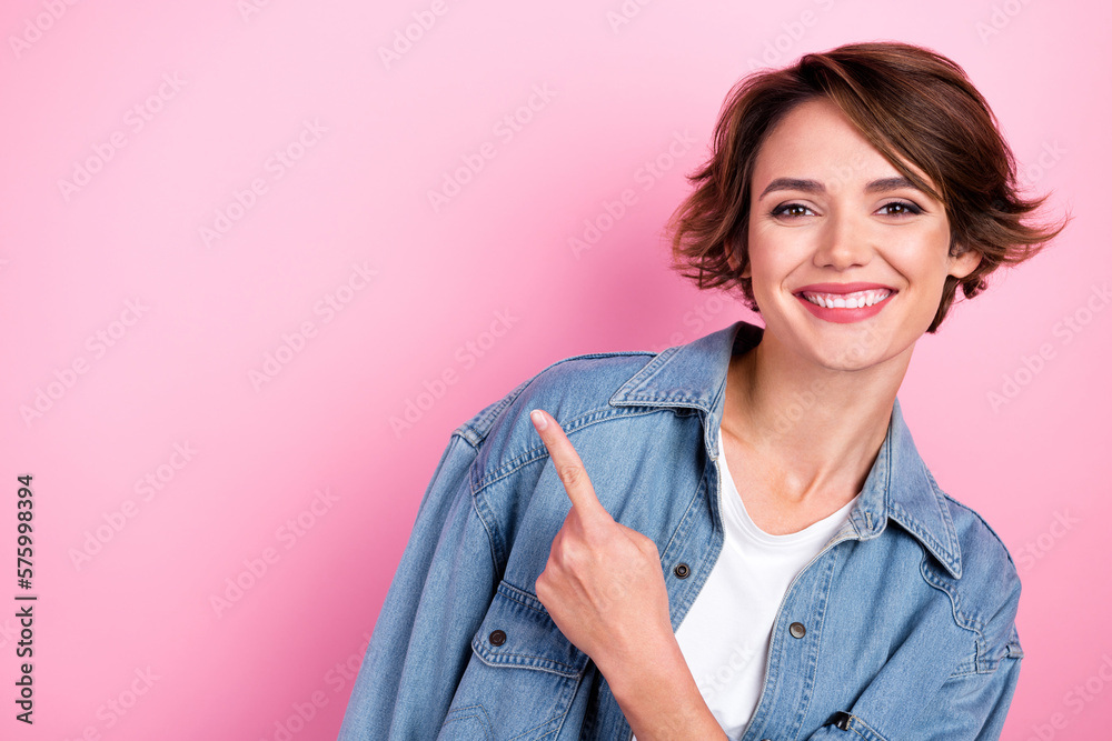 Photo portrait of cheerful pretty woman wear denim jacket directing finger empty space opening whitening dentistry isolated on pink color background Photo portrait of cheerful pretty woman wear denim jacket directing finger empty space opening whitening dentistry isolated on pink color background