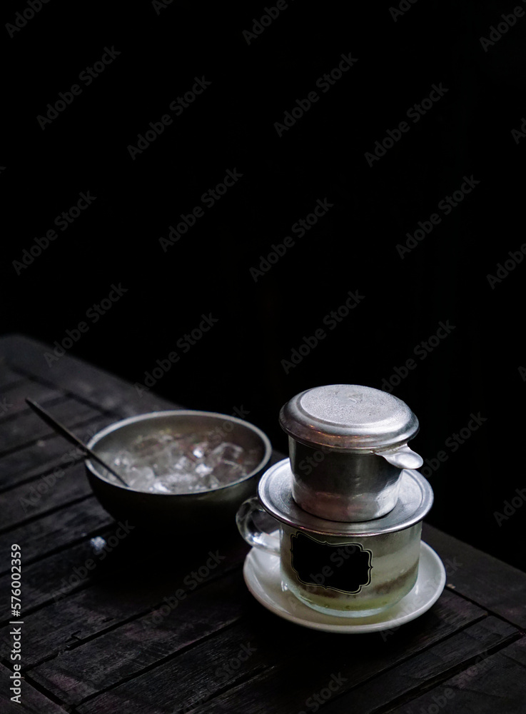 Salted coffee filter glass served with a bowl of ice on a wooden table                               