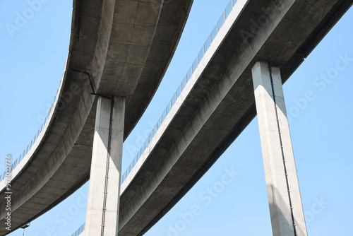 Elevated expressway during a sunny day .  highway overpass against blue sky .  Motorway viaduct interchange