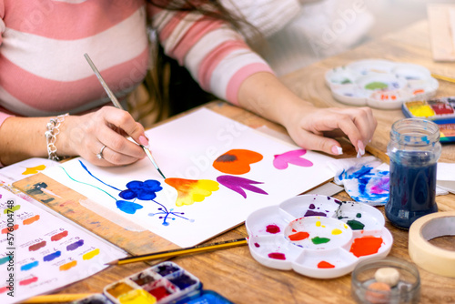 Watercolor Painting Workshop. Close-up of woman using paintbrush and watercolor paints