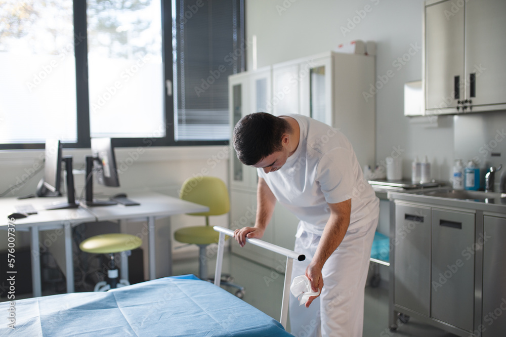 Young man with down syndome working in hospital as helper, cleaner. Concpet of integration people with disability into society. Young man with down syndome working in hospital as helper, cleaner. Concpet of integration people with disability into society.