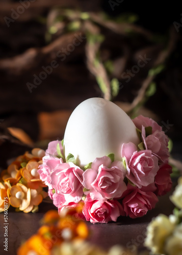 Easter egg decorated with pink flowers on a wooden background. Selective focus