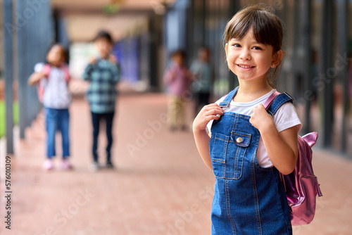Portrait Of Smiling Female Elementary School Pupil Outdoors With Backpack At School