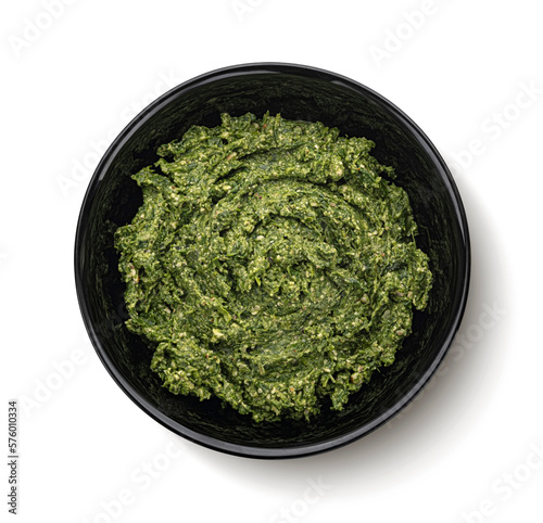 Pesto in black bowl isolated on white background, top view