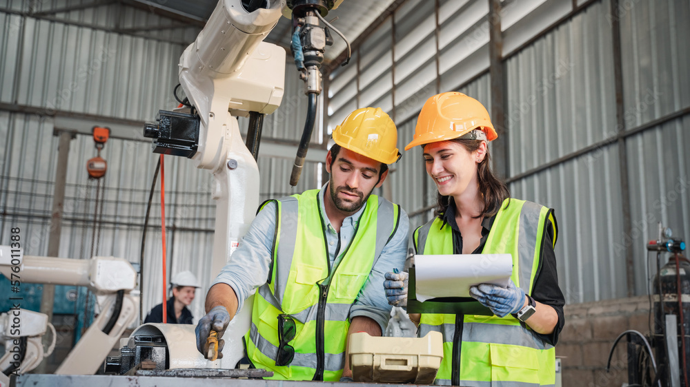 Industrial engineers are controlling the automated robot arms machine welding steel welding robots in industrial manufacturing factory. Industrial engineers are controlling the automated robot arms machine welding steel welding robots in industrial manufacturing factory.