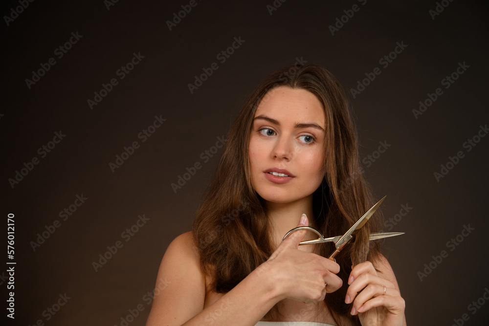 Obraz premium Portrait of young woman cutting her hair, cancer solidarity concept.