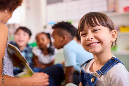 Portrait Of Smiling Female Elementary School Pupil Sitting In Classroom At  School