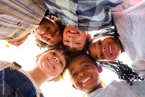 Low Angle Portrait Of Smiling Multi-Cultural Children Looking Down Into Camera © Monkey Business