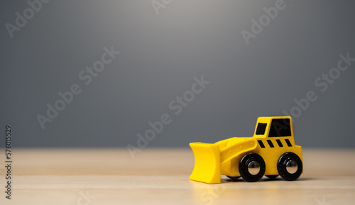 The yellow bulldozer toy. Construction works. Clearing and leveling the land. Building destruction. Take down Illegal construction. Industry © Andrii Yalanskyi