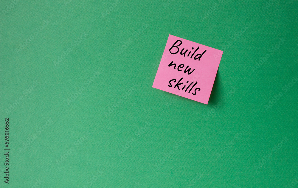 Build New skills symbol. Concept word Build New skills on pink steaky note. Beautiful green background. Business and Build New skills concept. Copy space Build New skills symbol. Concept word Build New skills on pink steaky note. Beautiful green background. Business and Build New skills concept. Copy space