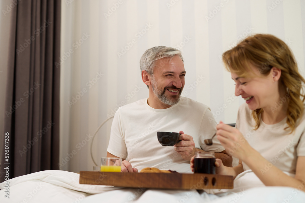 Mature couple enjoying coffee and breakfast in bed Mature couple enjoying coffee and breakfast in bed