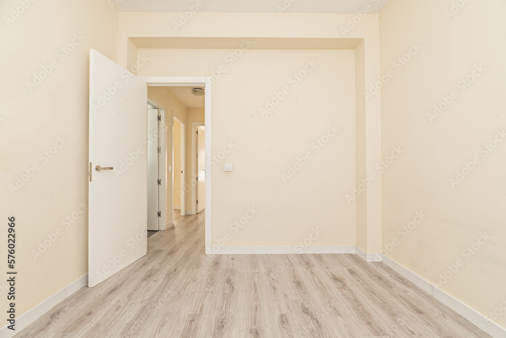 Empty room of an apartment with white wooden doors and skirting boards, a light wooden floor and cream painted walls Empty room of an apartment with white wooden doors and skirting boards, a light wooden floor and cream painted walls
