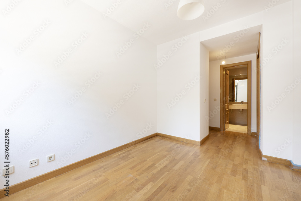 Empty room in a house with an oak floor, a dressing area and a toilet with a cream marble top Empty room in a house with an oak floor, a dressing area and a toilet with a cream marble top