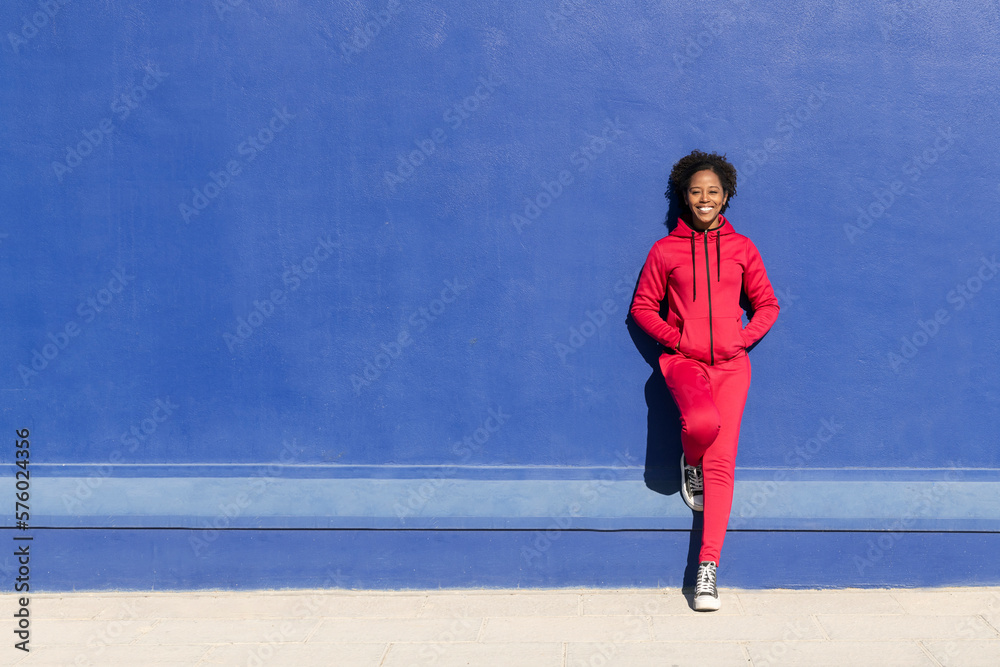 Happy woman standing with hands in pockets on sunny day Happy woman standing with hands in pockets on sunny day