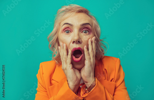 Shocked senior woman against turquoise background photo