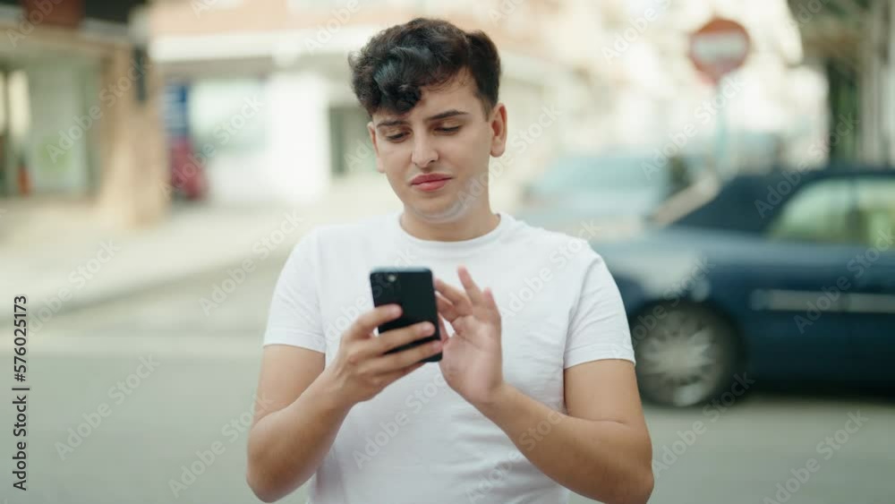 Non binary man using smartphone with relaxed expression at street Non binary man using smartphone with relaxed expression at street