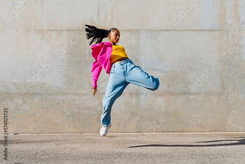 Young dancer hip hop dancing in front of wall