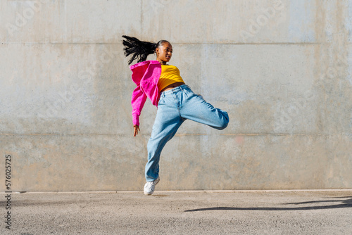 Young dancer hip hop dancing in front of wall photo