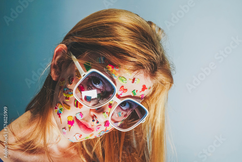 Blond woman with stickers over face wearing sunglasses photo