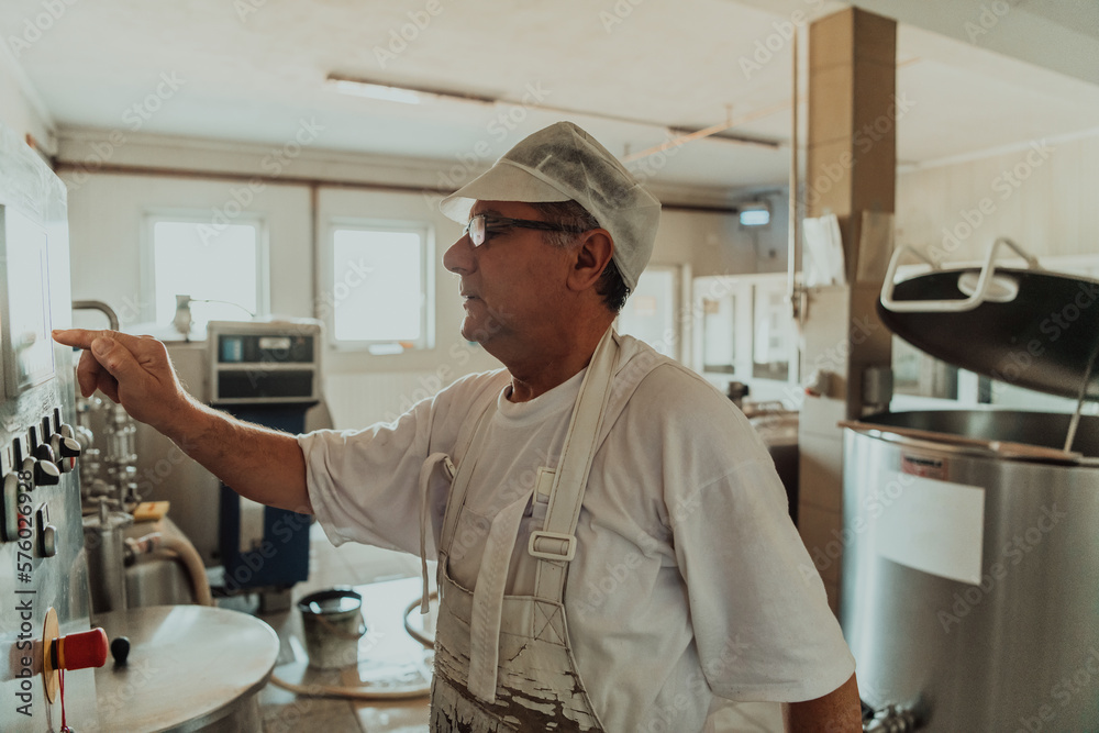 Cheese maker working in the modern industry on machines that are using for the machining of fresh cheese Cheese maker working in the modern industry on machines that are using for the machining of fresh cheese