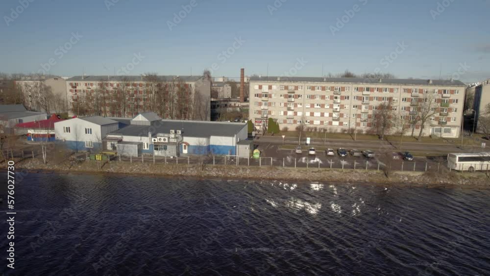 Old soviet buildings near river and port with cars Old soviet buildings near river and port with cars