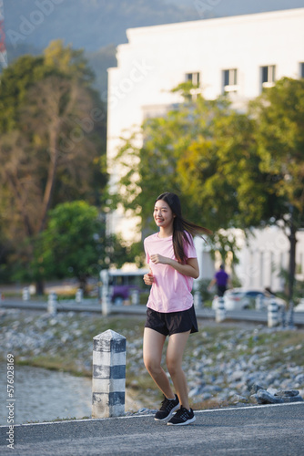 Beautiful Healthy woman running jogging in the park in the morning. She smiled and enjoyed. Healthy active lifestyle concept. © skarie