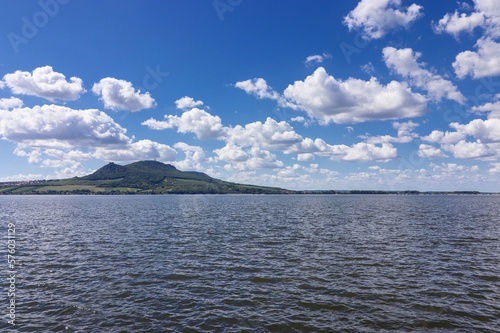 A view to the Palava hills and white clouds surrounded by the pond near Strachotin, Czech republic