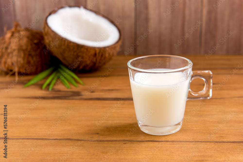 Coconut milk on wooden table Coconut milk on wooden table