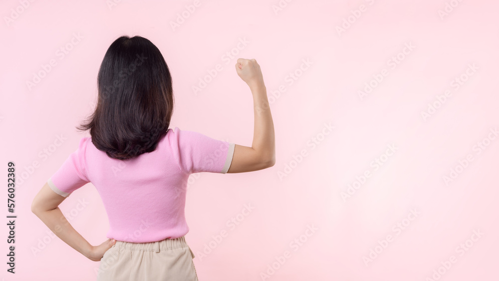 Portrait back of woman proud and confident showing strong muscle strength arms flexed posing, feels about her success achievement. Women empowerment, equality, healthy strength and courage concept Portrait back of woman proud and confident showing strong muscle strength arms flexed posing, feels about her success achievement. Women empowerment, equality, healthy strength and courage concept
