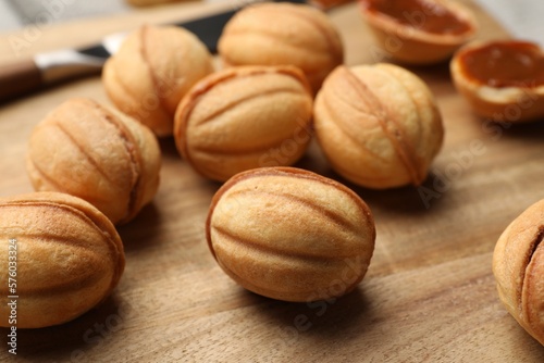 Homemade walnut shaped cookies with boiled condensed milk on wooden board, closeup