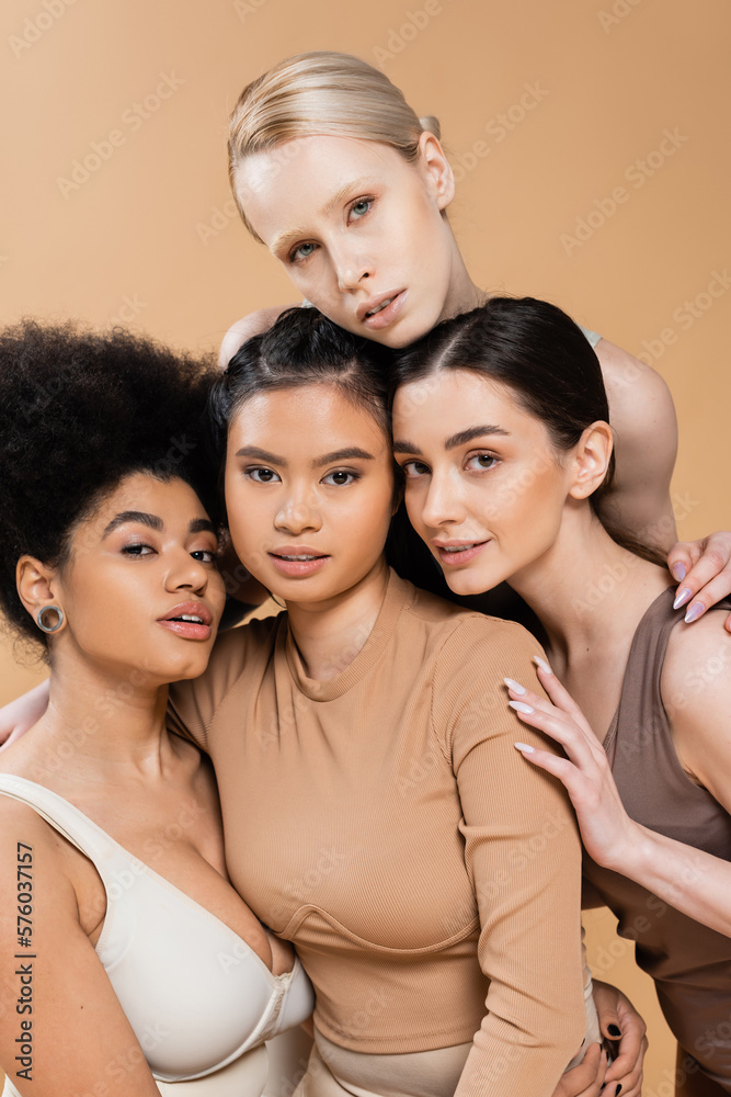 Fototapeta premium sensual multicultural models in underwear looking at camera isolated on beige.