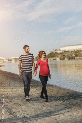 Expecting Couple Enjoying Walk Near The River