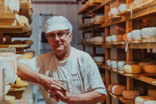 Foto A worker at a cheese factory sorting freshly processed cheese on drying shelves
