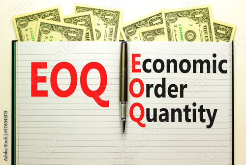 EOQ economic order quantity symbol. Concept words EOQ economic order quantity on white note on beautiful background from dollar bills. Pen. Business EOQ economic order quantity concept. Copy space.