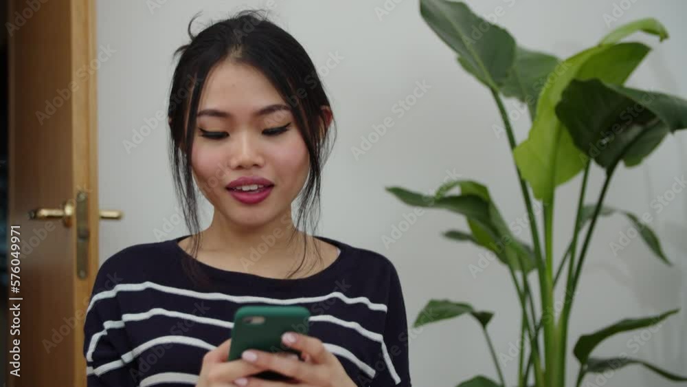 Young Smiling Woman Using Mobile Phone At Home. Young Smiling Woman Using Mobile Phone At Home.