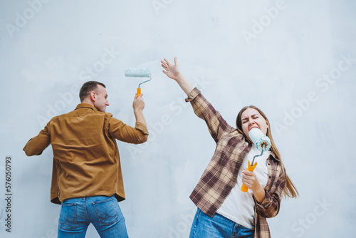 Foto Young married couple in love in shirts and jeans doing renovations, renewing pai