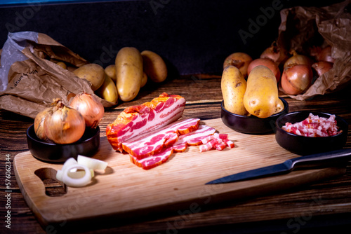 Plateau d'ingrédients bruts pour la préparation d'une tartiflette avec un arrière-plan sombre photo