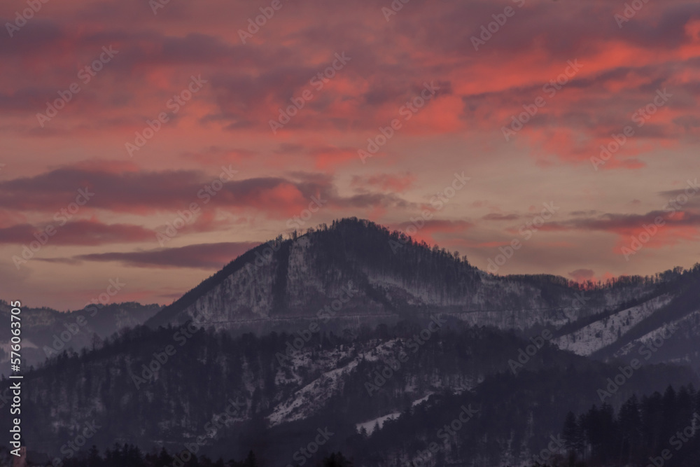 Winter morning with color clouds and big dark hills