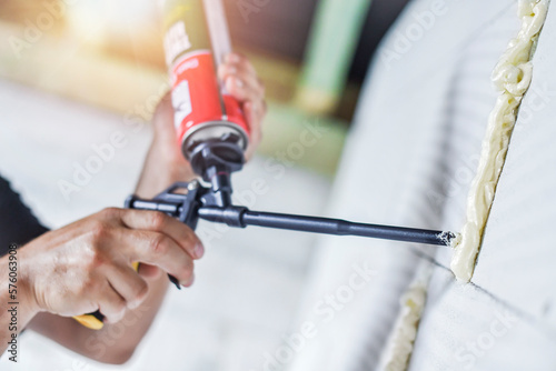 Fotografi Worker hands is using a polyurethane or montage foam.