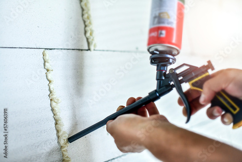 Worker hands is using a polyurethane or montage foam. photo