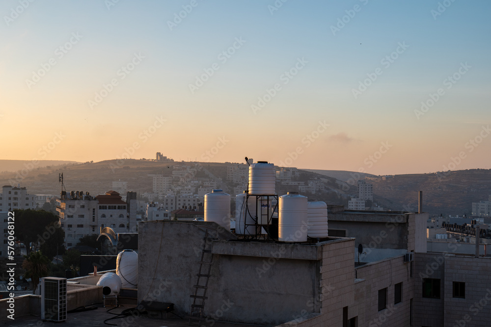 Ramallah Cityscape at Dawn with High Buildings and Trees Facing the Sun