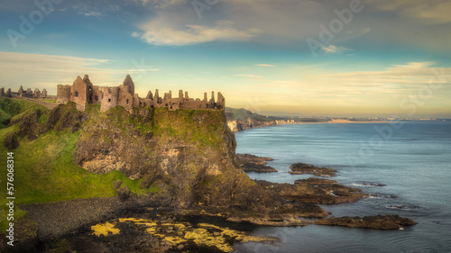 Old ruins of Dunluce Castle located on the edge of cliff at sunrise, Bushmills, Northern Ireland. Filming location of popular TV show Game of Thrones