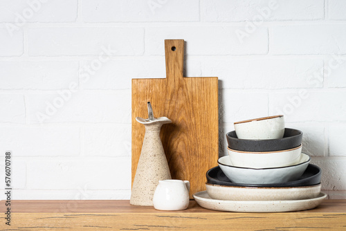 Kitchen table, kitchen utensils, plates, bowls and wooden cutting board, whiye background. Modern kitchen interior. photo