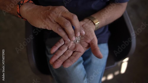 Close up of Hand of Indian man with Paan Masala aka Gutka or Supari is a chewing tobacco, tobacco is injurious to health 