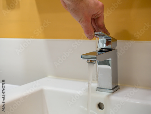 Running water from a square faucet in a modern bathroom