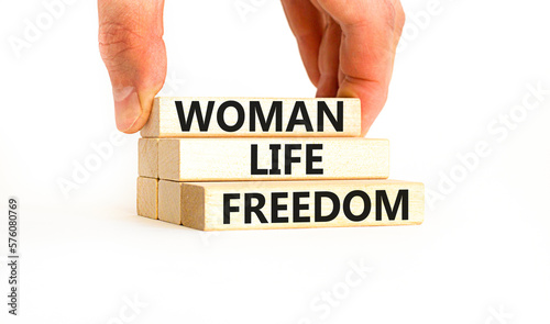 Woman life freedom symbol. Concept words Woman Life Freedom on wooden blocks on a beautiful white table white background. Businessman hand. Social issue woman life freedom concept. Copy space.