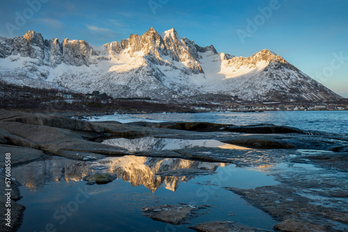 Snow covered mountain range on coastline in winter, Norway. Senja panoramic aerial view landscape nordic snow cold winter norway ocean cloudy sky snowy mountains. Troms county, Fjordgard  © Michal