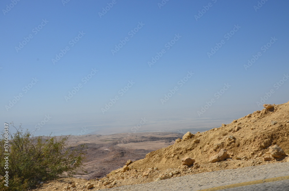 Landscapes of a road crossing the dry desert of Jordan under a bright sunny day